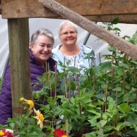 Rosemary Freeman and Elva Sellens enjoy the greenhouse at the Piper Creek Trial Garden